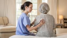 Healthcare practitioners examining a patient at home
