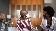 Doctor in mask talking to patient in mask