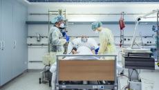 Doctors with patient in hispital bed
