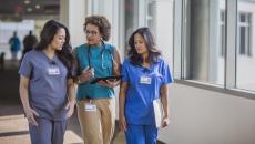 Three healthcare professionals conversing 