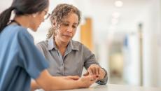 A healthcare provider speaking to an individual in a clinical setting