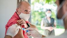 An older man getting a vaccine. 