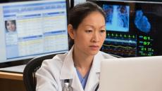 A doctor reviewing a patient's record on a laptop computer