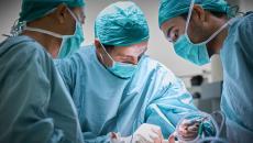 Three surgeons operating on a patient