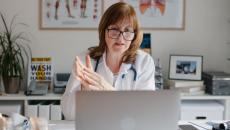 A doctor using a laptop for a virtual consultation 